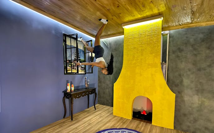 Person hanging upside down in a room at Upside Down World Bali.