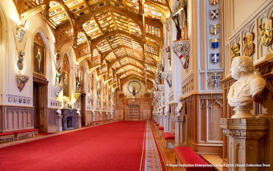 Windsor Castle interior with ornate ceiling, red carpet, and historical busts.