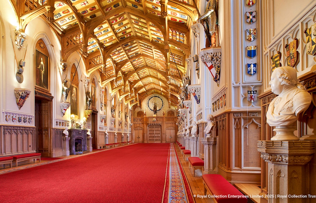 Windsor Castle interior with ornate ceiling, red carpet, and historical busts.