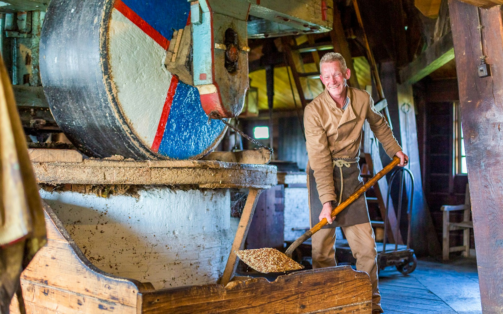 Man working in a traditional Dutch windmill at Zaanse Schans during a full-day tour from Amsterdam.