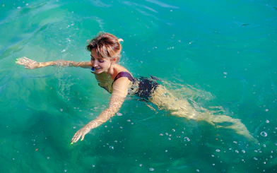 Guest swimming in Komani Lake during day trip from Tirana.