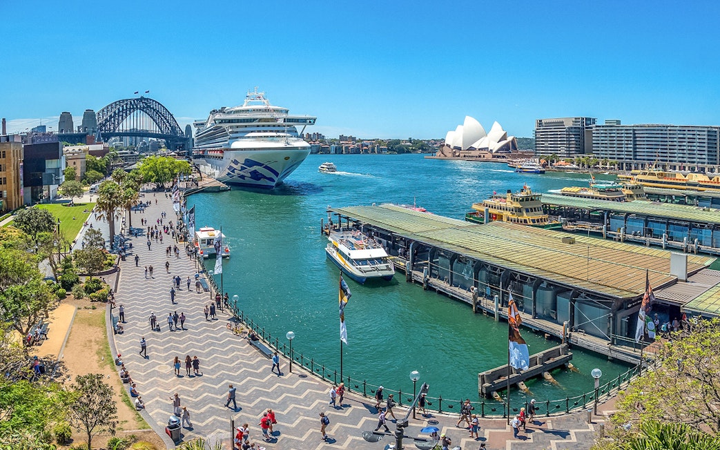 Cruise ship docked at Circular Quay with Sydney Opera House and Harbour Bridge in view.