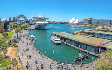 Cruise ship docked at Circular Quay with Sydney Opera House and Harbour Bridge in view.