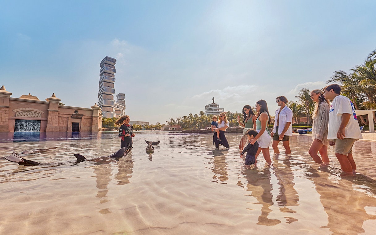 Tourists interacting with dolphins at Atlantis, The Palm, Dubai.