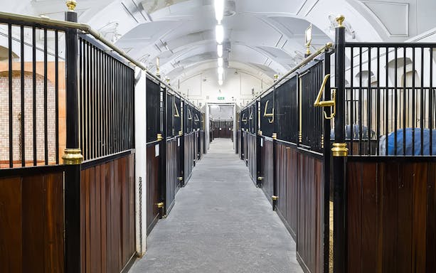 Stallburg Imperial Stables interior with rows of horse stalls in Vienna.