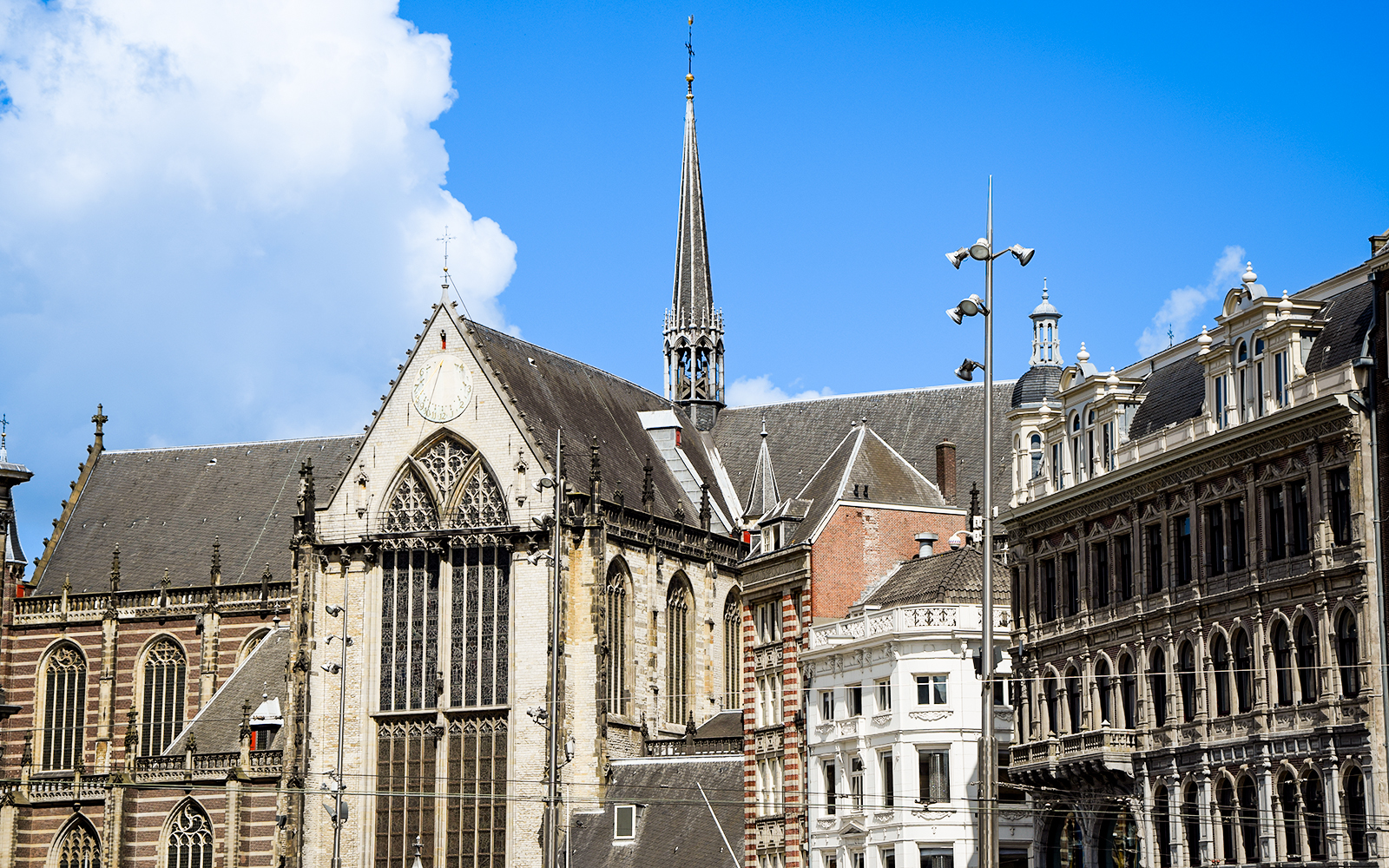 Nieuwe Kerk in Amsterdam with its Gothic architecture and spire against a blue sky.