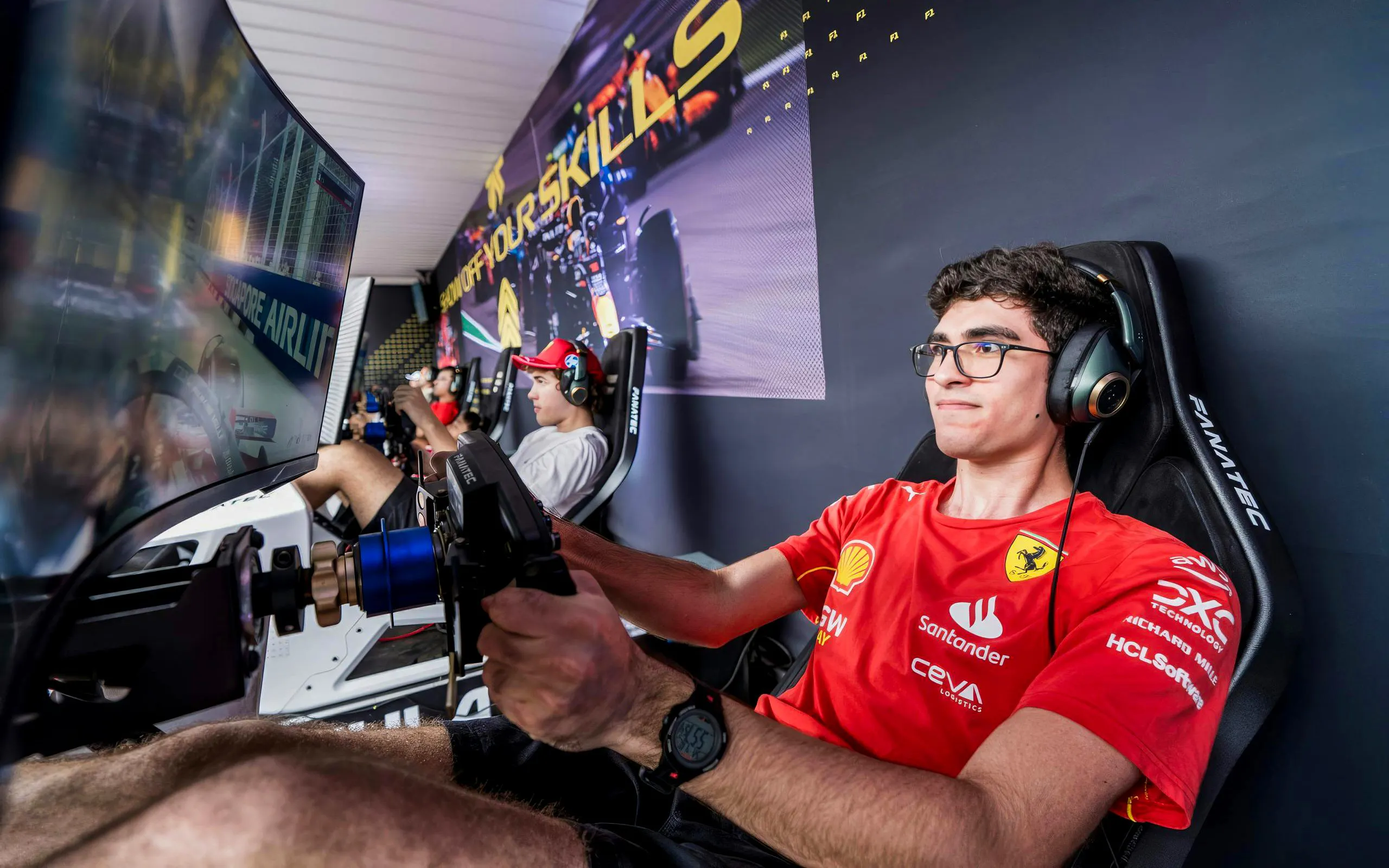 Racer in Ferrari Esports shirt focused on racing simulator setup.
