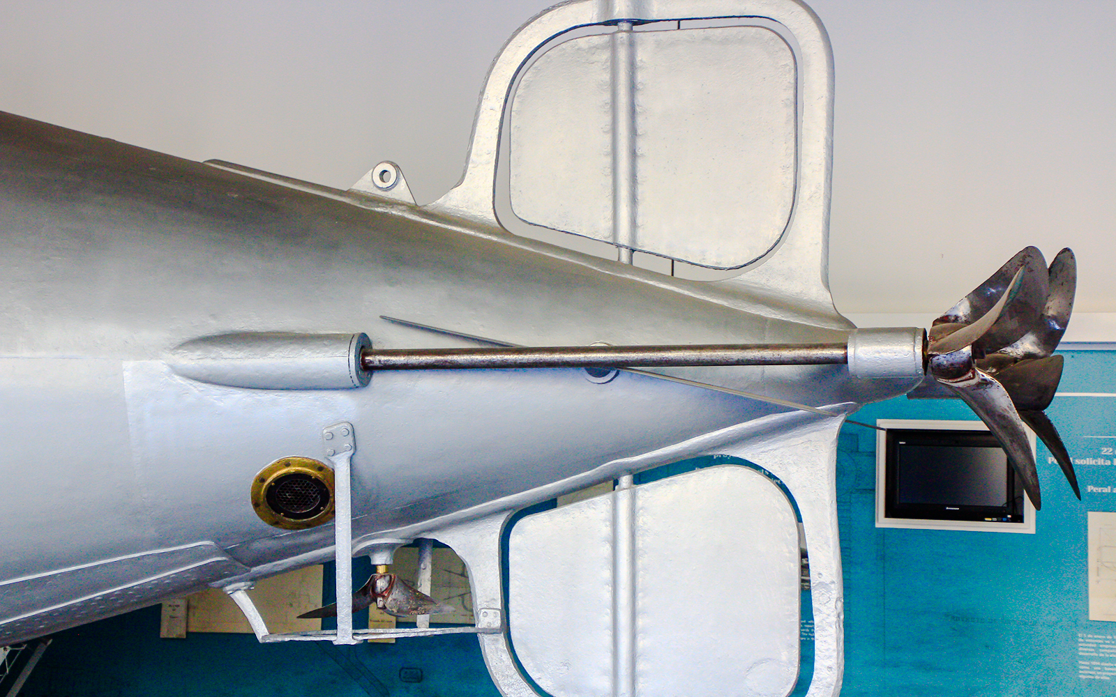 Torpedo detail with propeller and fins on display in a museum exhibit.