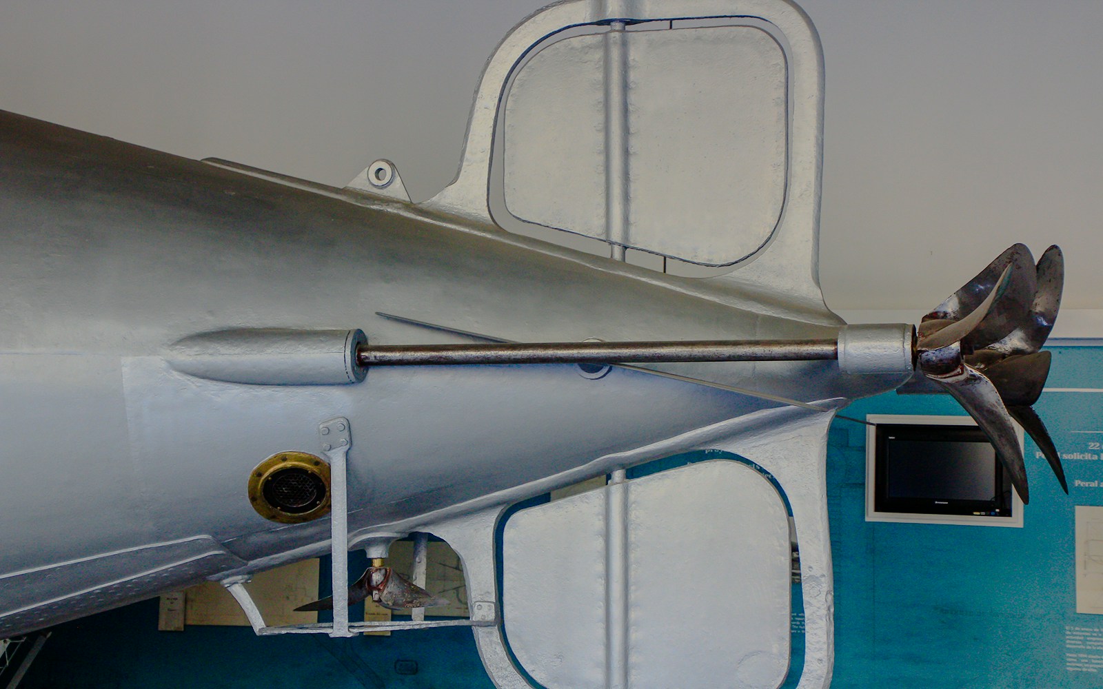 Torpedo detail with propeller and fins on display in a museum exhibit.