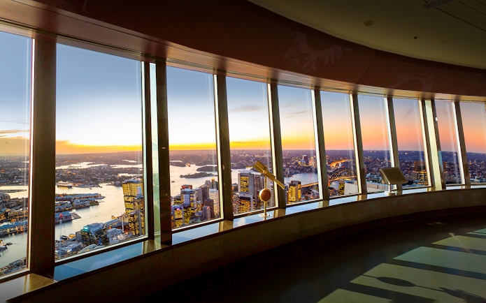 View of Sydney skyline and harbor from observation deck at sunset.