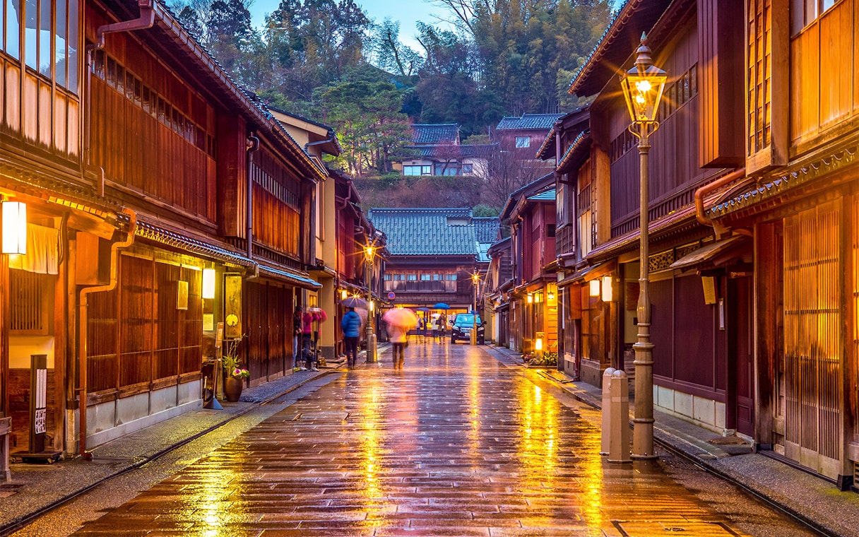 Traditional street in Kanazawa, Japan, with wooden buildings and glowing lanterns, part of Hokuriku Area Pass.