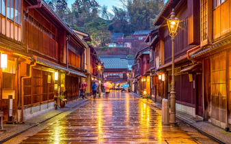 Traditional street in Kanazawa, Japan, with wooden buildings and glowing lanterns, part of Hokuriku Area Pass.