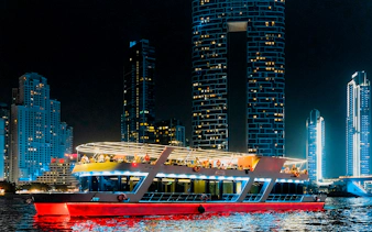 Sunset cruise boat with buffet dinner in Dubai Marina at night.