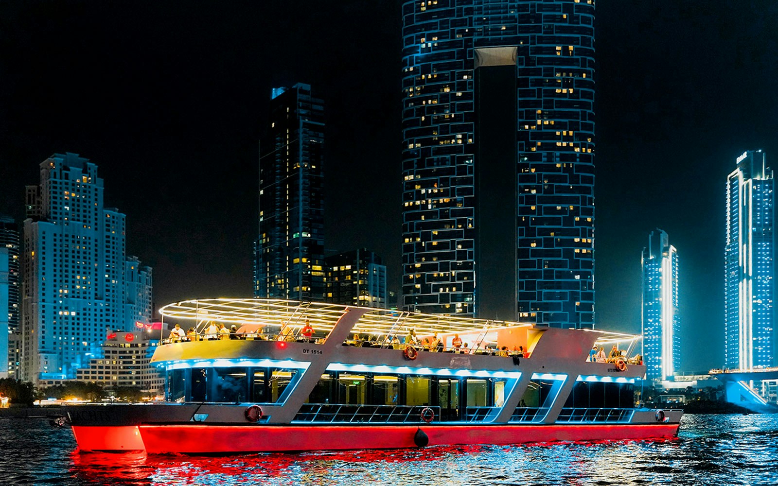 Dubai Marina sunset cruise with buffet dinner, featuring a yacht on calm waters and city skyline.