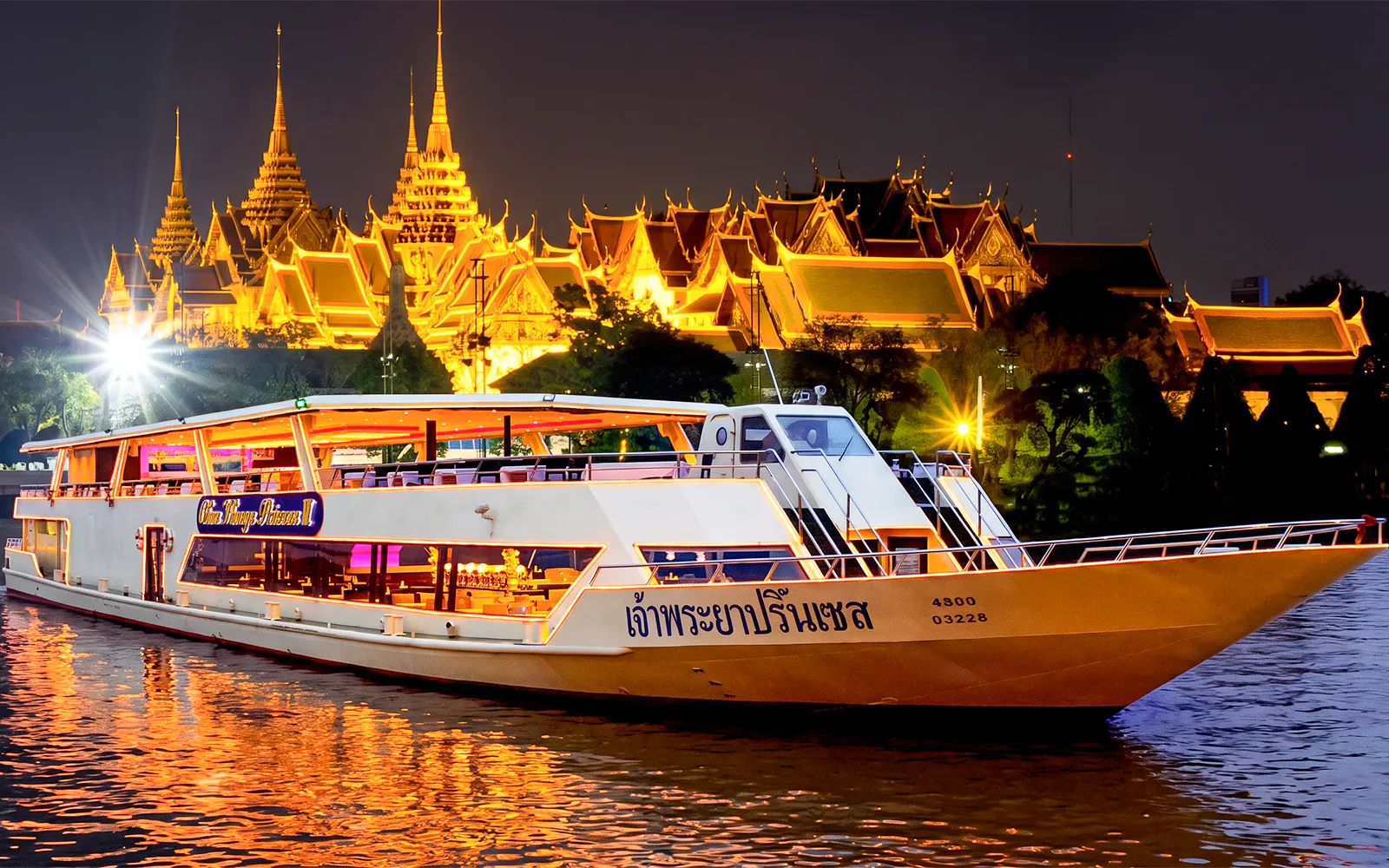 Chao Phraya Princess cruise at night with illuminated temple in Bangkok.