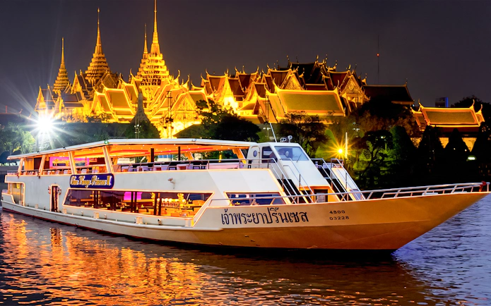 Chao Phraya Princess cruise at night with illuminated temple in Bangkok.