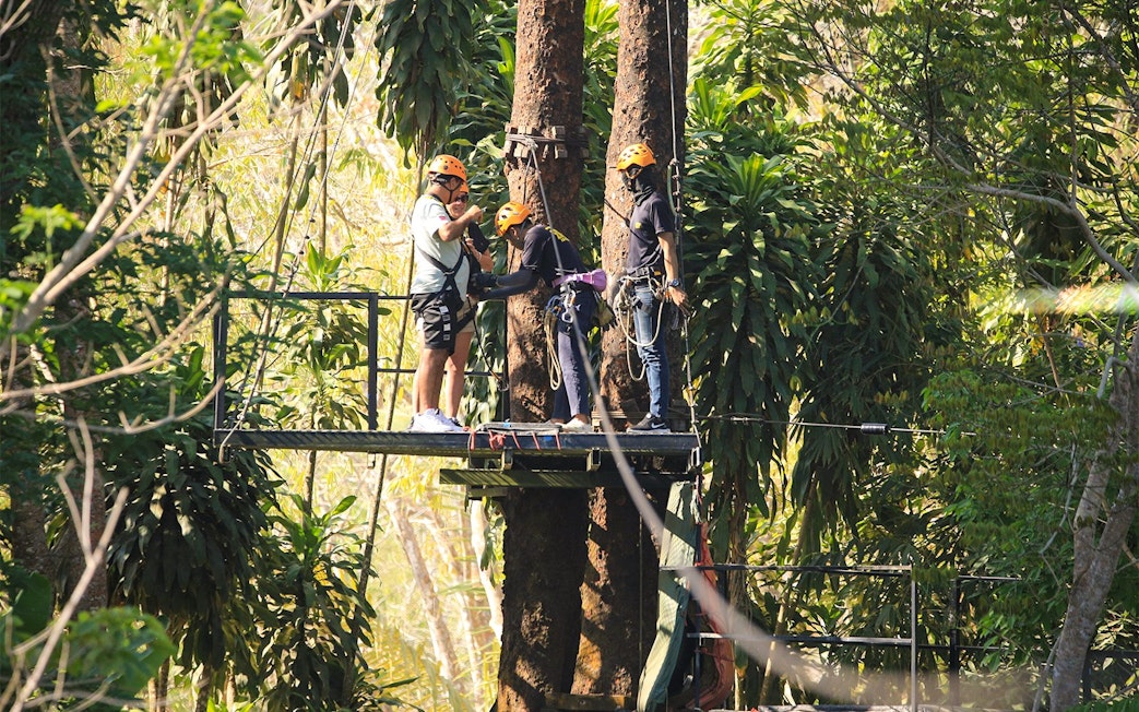 Participants preparing for a zipline adventure in Phuket's lush forest.