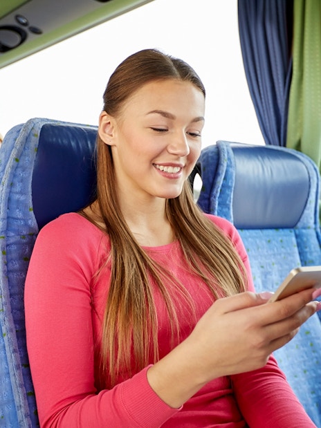 Passenger using phone inside a tour bus.