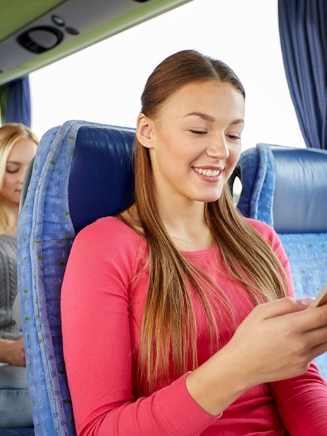 Passenger using phone inside a tour bus.