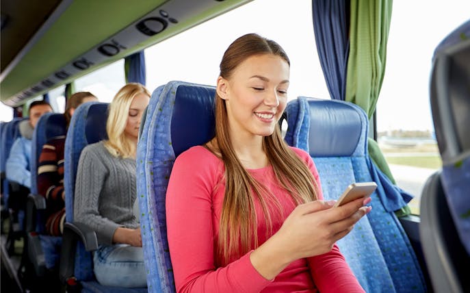 Passenger using phone inside a tour bus.