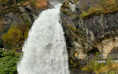 Steinsdalsfossen Waterfall with visitors on viewing path, Folgefonna National Park, Norway.