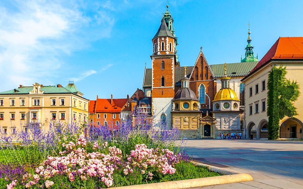 Wawel Cathedral with colorful flowers in the foreground, Kraków, Poland.