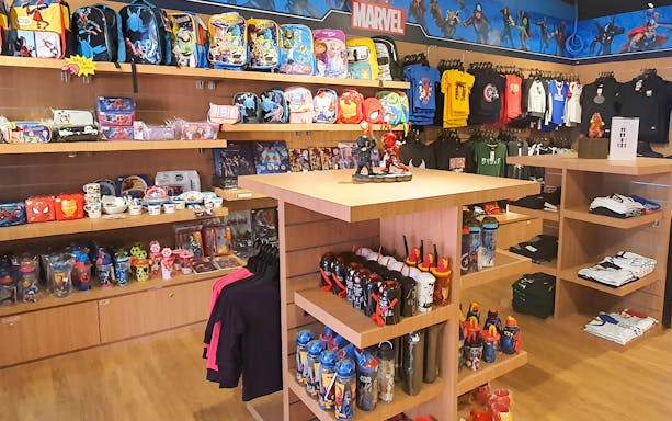 Merchandise shop with superhero-themed backpacks and apparel at Wonderpark Melaka.