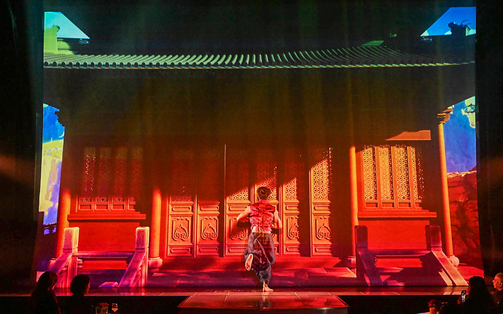 Performer on stage at Paris cabaret show with vibrant backdrop.