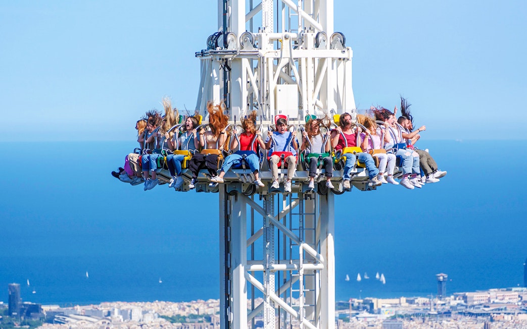 Visitors on the Merlin ride at Tibidabo Amusement Park with a view of Barcelona.
