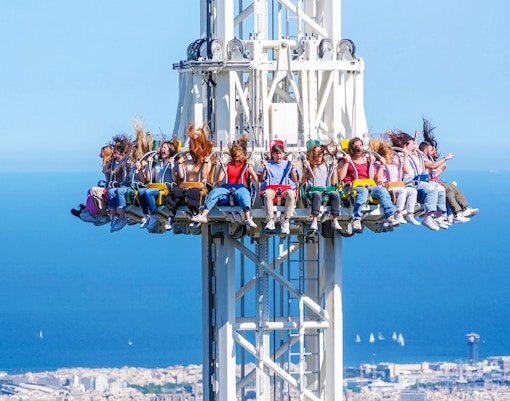 Visitors on the Merlin ride at Tibidabo Amusement Park with a view of Barcelona.