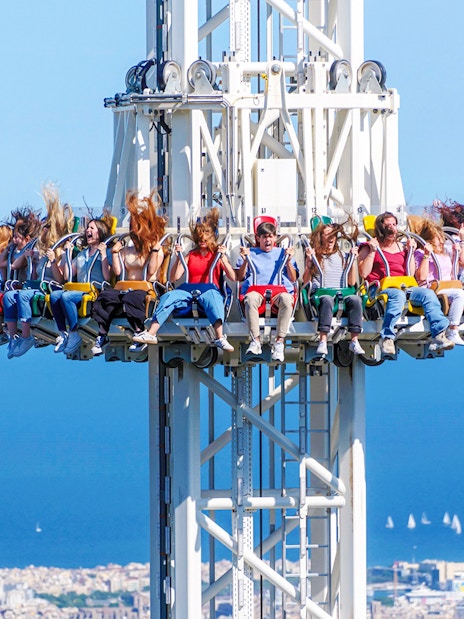 Visitors on the Merlin ride at Tibidabo Amusement Park with a view of Barcelona.