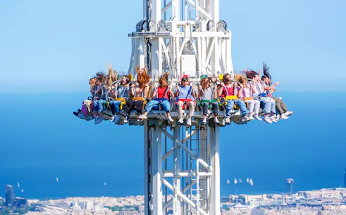 Visitors on the Merlin ride at Tibidabo Amusement Park with a view of Barcelona.