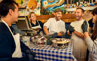 Participants enjoying a Dutch syrup waffle making workshop with a chef in Amsterdam.