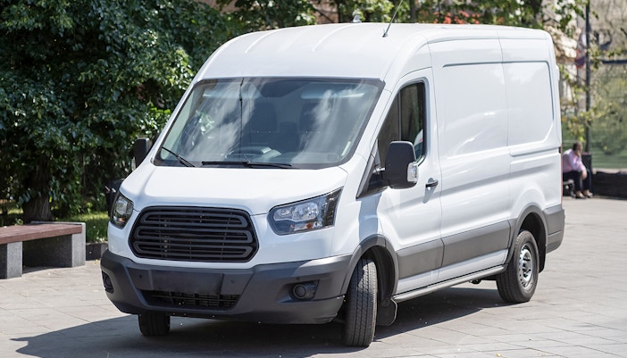 Minibus parked on a city street for transfer services.