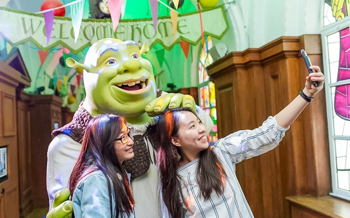 Visitors taking a selfie with Shrek at Shrek's Adventure! London.
