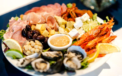 Seafood platter with prawns, oysters, cheese, and olives on Darwin Harbour Sunset Dinner Cruise.
