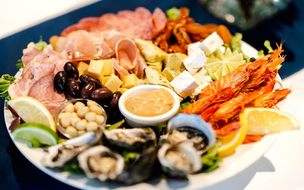 Seafood platter with prawns, oysters, cheese, and olives on Darwin Harbour Sunset Dinner Cruise.