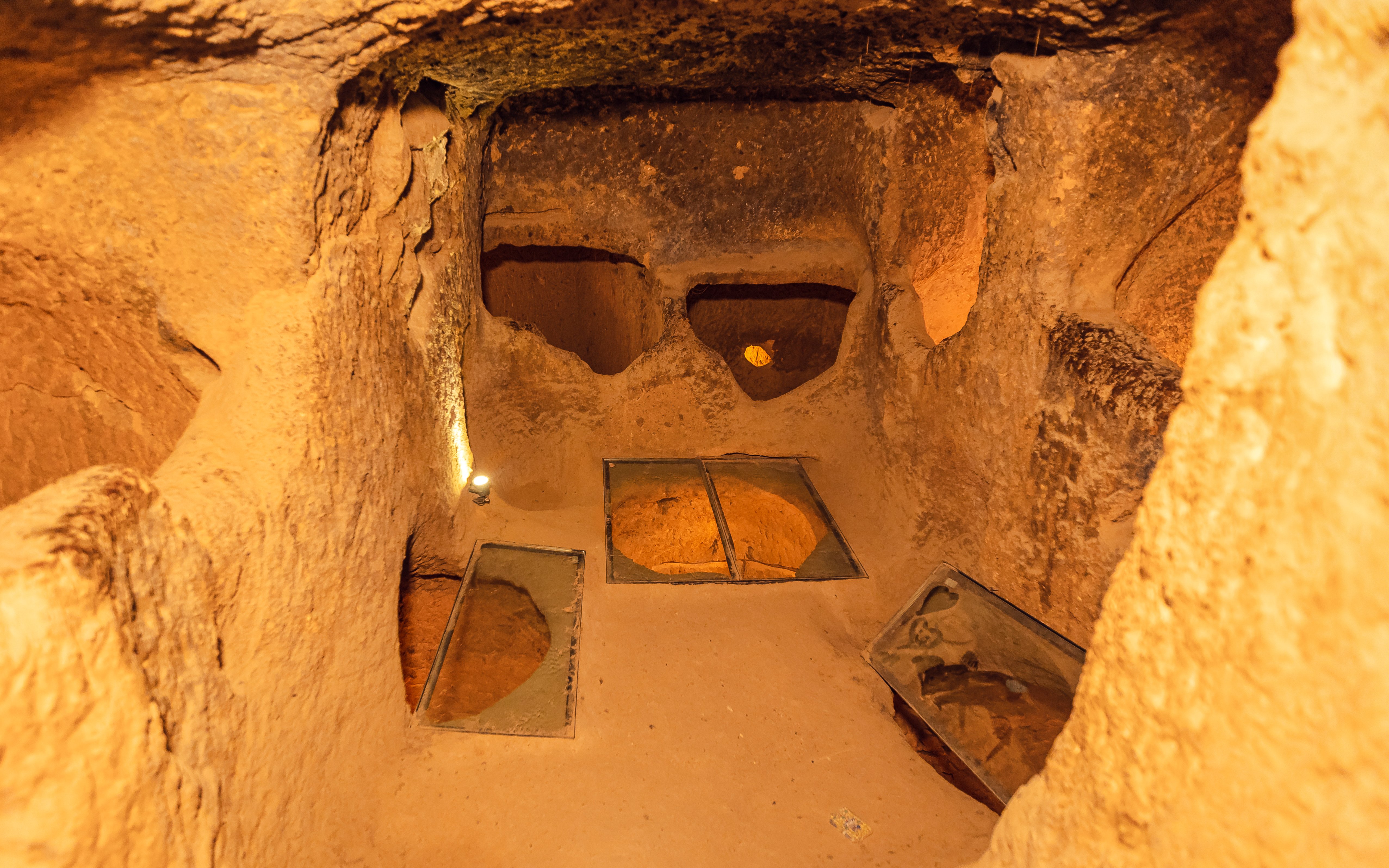 Ozkonak underground city chamber with stone walls and ventilation holes.