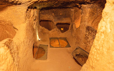 Ozkonak underground city chamber with stone walls and ventilation holes.