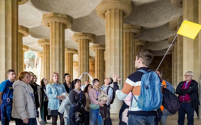 Tour group with guide in the hypostyle hall of Park Güell, Barcelona.