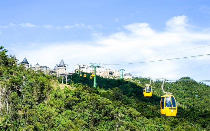 Cable cars at Sun World Ba Na Hills, Da Nang, Vietnam, with castle-like structures in the background.