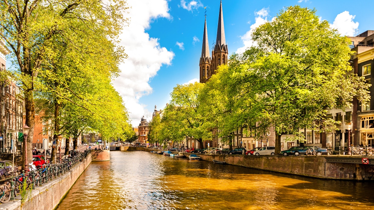 Singel Canal in Amsterdam with Bartolotti House and tree-lined banks.