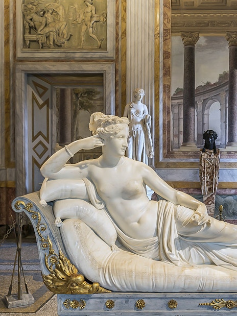 Borghese Gallery sculpture room with reclining marble statue and classical decor.