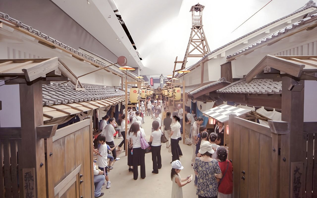 Visitors exploring Edo-period street replica at Osaka Museum of Housing and Living, Japan.