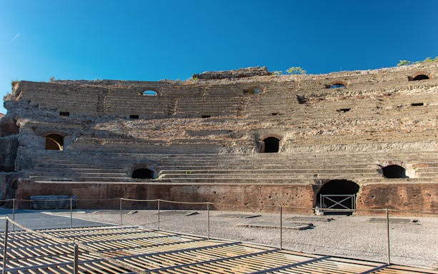 Flavian Amphitheater in Pozzuoli with ancient stone seating and arches.