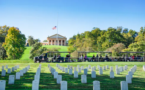 Tram tour passing through Arlington National Cemetery with Arlington House in the background.