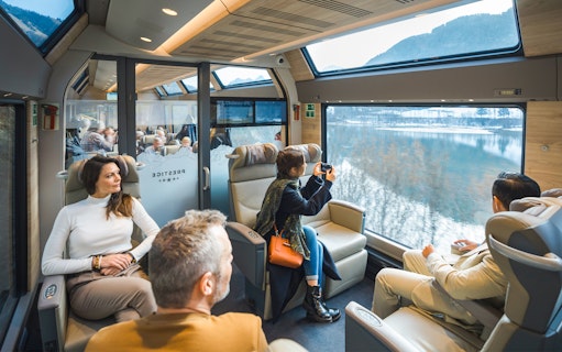 Passengers enjoying views on the GoldenPass Express train from Montreux to Interlaken.
