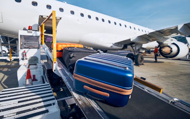 Luggage on conveyor belt near airplane at Incheon airport.