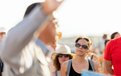 Tourists attentively listening to a guide's explanation outdoors.