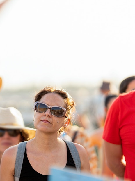 Tourists attentively listening to a guide's explanation outdoors.